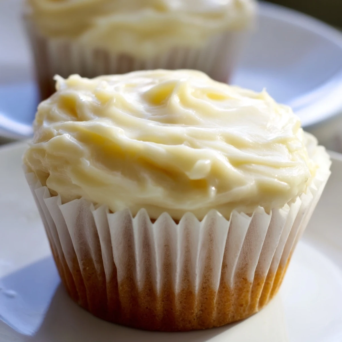 A close-up of delicious vanilla cupcakes, their buttercream frosting swirled high and ready to enjoy.