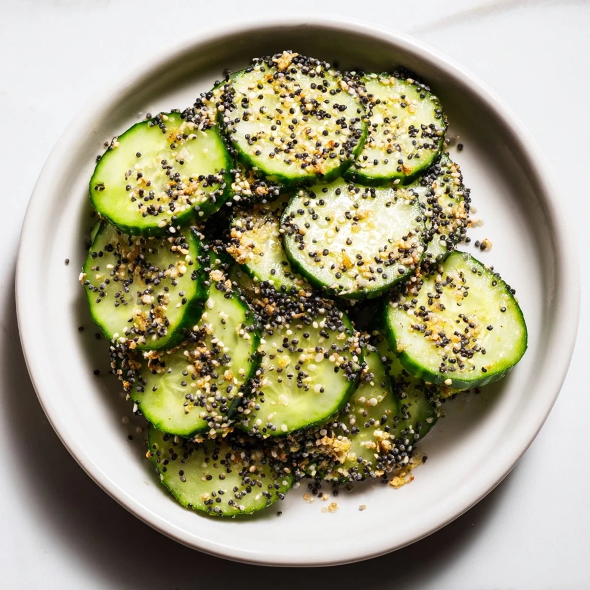 Fresh Cucumber Shaker with Everything Bagel Seasoning: bright, vibrant slices glistening with savory seasonings ready to enjoy.