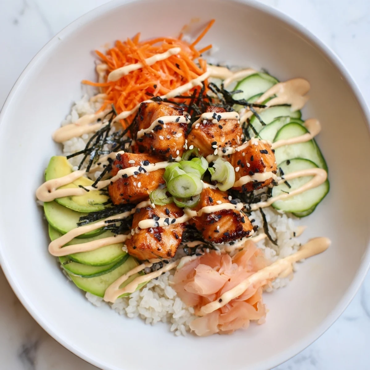 Savory salmon bites atop rice, a vibrant bowl with carrots and sesame seeds, ready to eat.