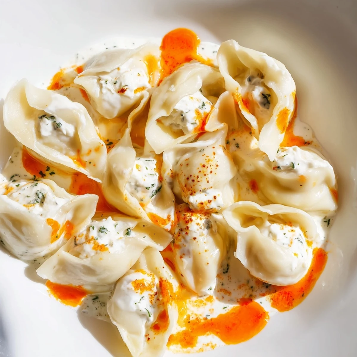 A beautifully presented plate of perfectly cooked Turkish Cheesy Manti with a vibrant butter drizzle.