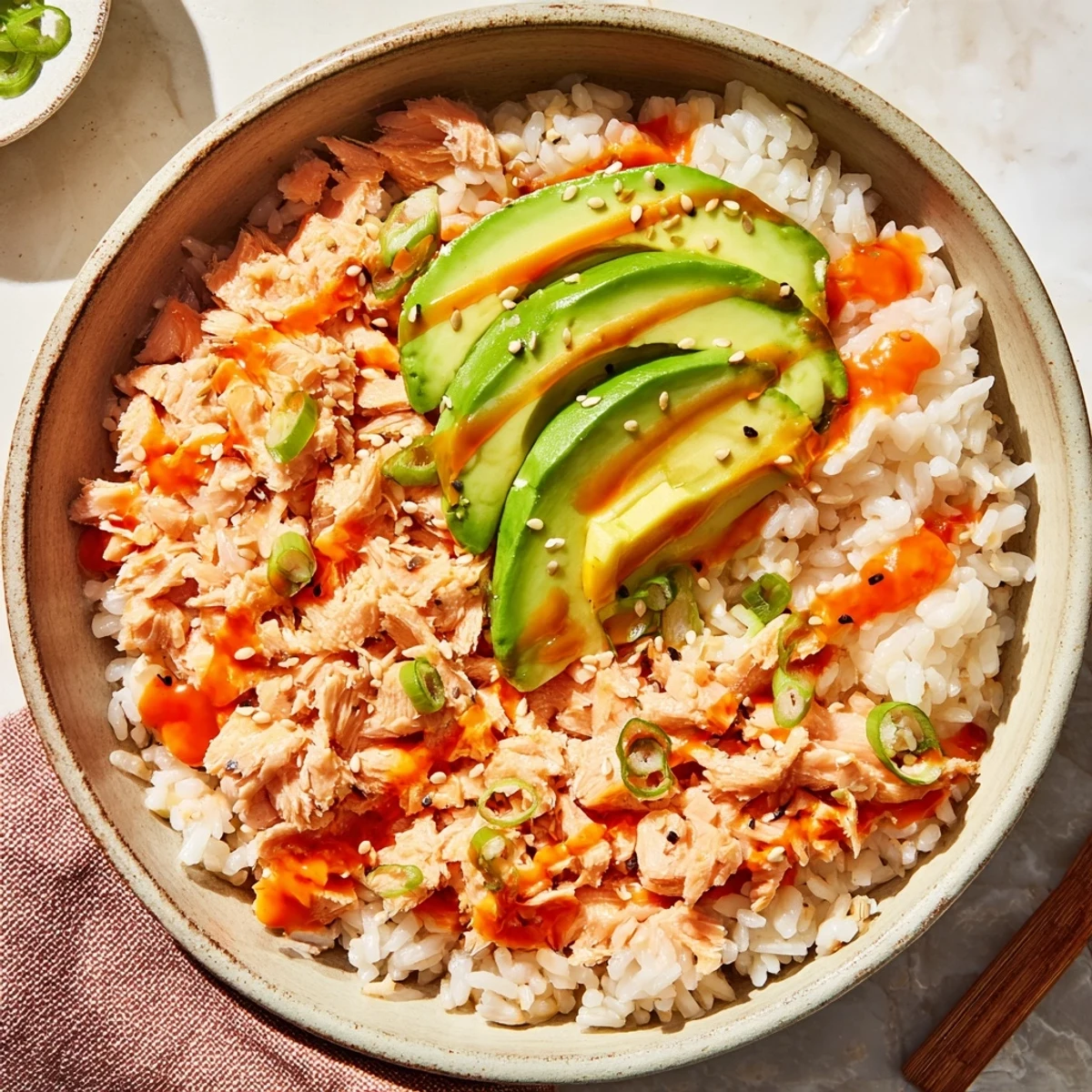 A close-up of Emily Mariko Salmon Rice Bowl topped with sesame seeds and fresh green onions.