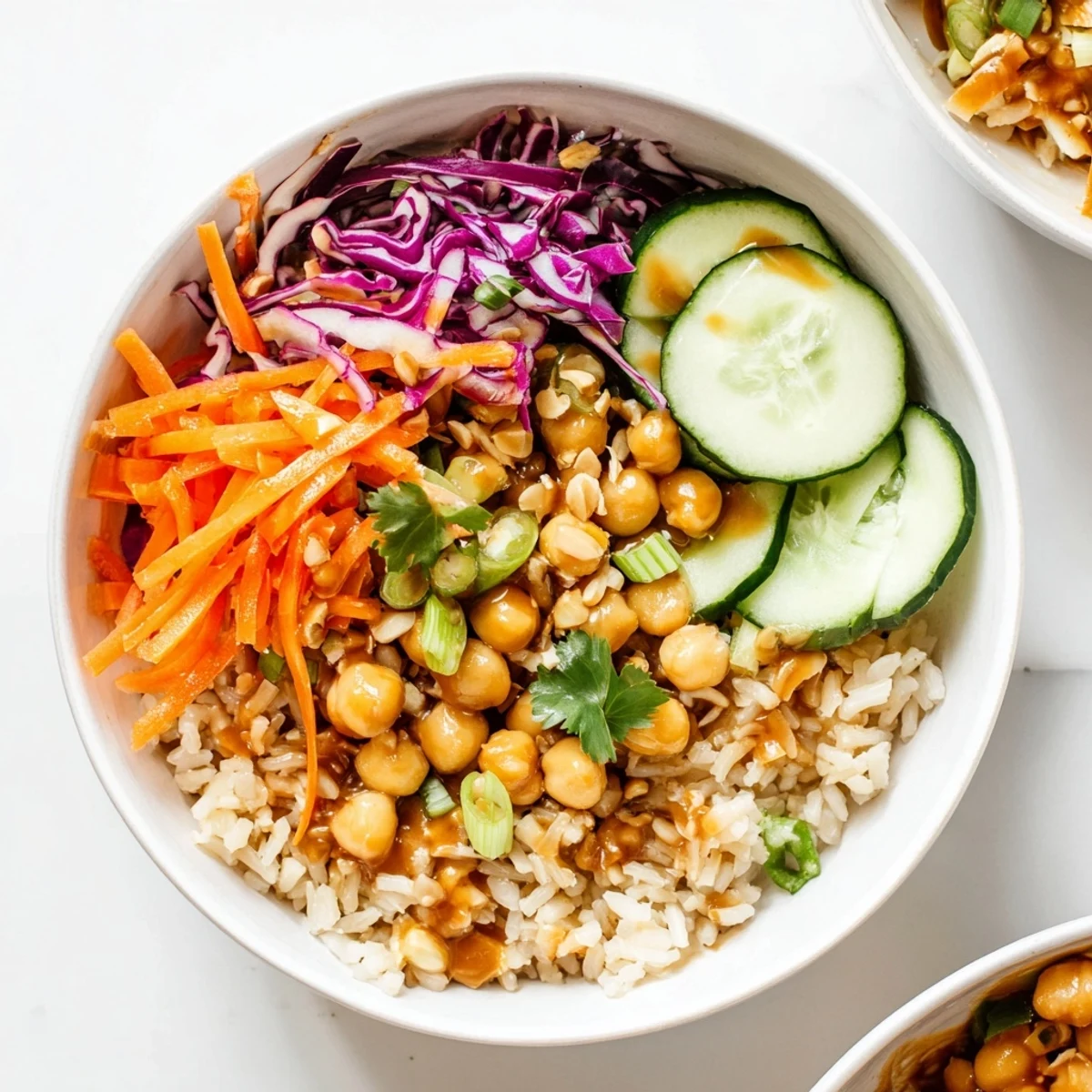 The finished Peanut Chickpea Rice Bowl garnished with fresh cilantro and roasted peanuts, ready to serve.