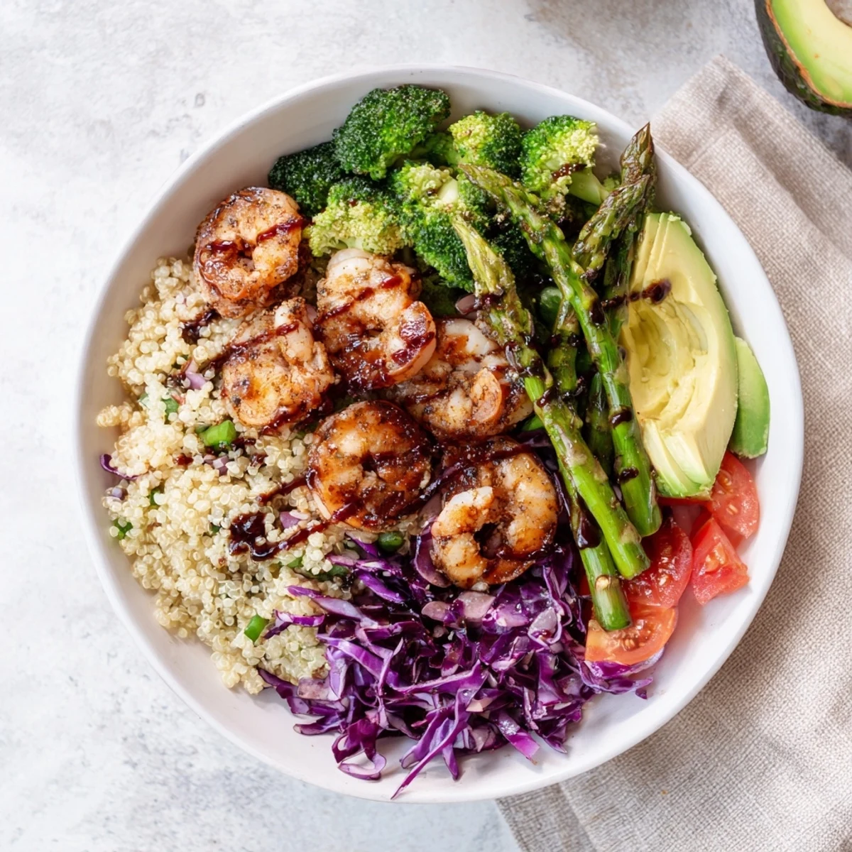 Colorful Detox Buddha Bowl with Shrimp and Quinoa, topped with crisp broccoli, asparagus, and creamy avocado slices.