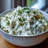 Tender Creamed Cabbage in a skillet, sautéed with onions and ready to serve alongside roast chicken