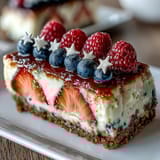 Patriotic no-bake cheesecake featuring creamy filling and vibrant red, white, and blue berries.  