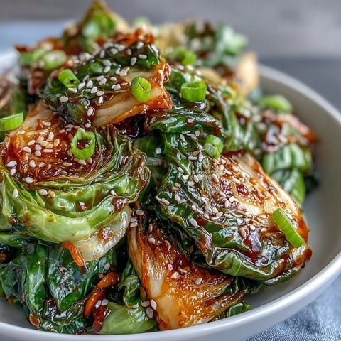 Freshly stir-fried Hot and Sour Cabbage with tender-crisp green cabbage and bright carrots in a spicy, tangy sauce served as a side dish.