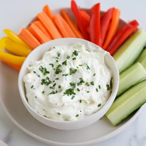 Fresh veggie sticks surround a bowl of rich Kids Dip, perfect for a healthy, fun snack.