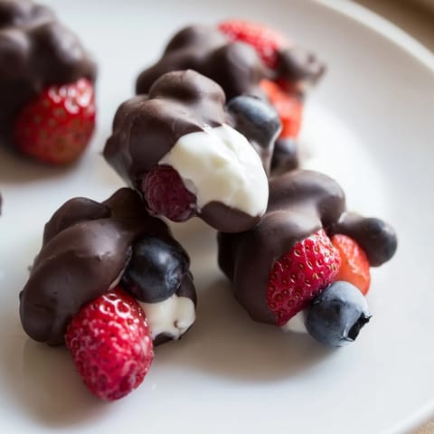 Melted chocolate envelops cool, berry-filled Chocolate Yogurt Clusters, a deliciously easy frozen treat.