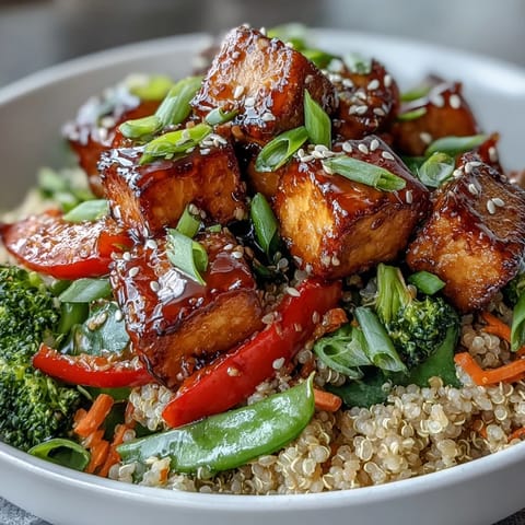 Overhead view of a wholesome Quinoa Vegetable Teriyaki Bowl, with fluffy quinoa, colorful stir-fried veggies, sesame seeds, and green onions on top.