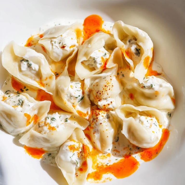 A beautifully presented plate of perfectly cooked Turkish Cheesy Manti with a vibrant butter drizzle.