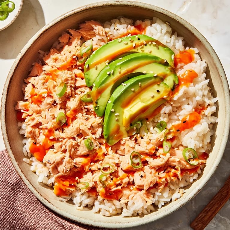 A close-up of Emily Mariko Salmon Rice Bowl topped with sesame seeds and fresh green onions.