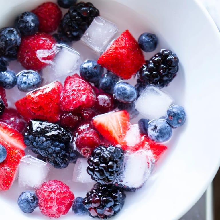 Close-up of Natures Cereal Bowl featuring fresh berries and glistening ice cubes in coconut water.