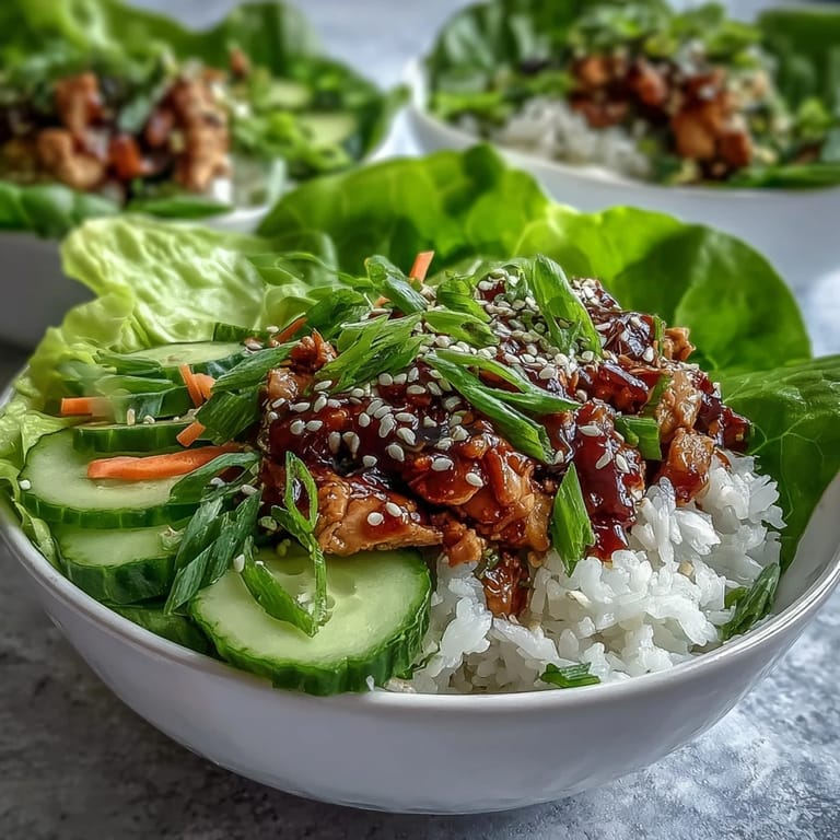 Top-down shot of a nutritious Sesame Turkey Lettuce Wrap Bowl, highlighting the tender ground turkey, colorful vegetable toppings, and toasted sesame seeds on a wooden table.