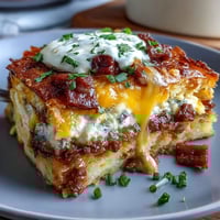 Amish Breakfast Casserole with golden hash browns, sausage, and melted cheese, baked to perfection for a hearty morning meal.